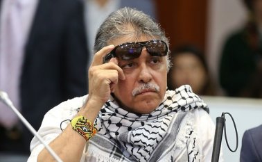La foto muestra a Santrich, quien es ciego, levantándose las gafas oscuras en medio de la ceremonia. Colprensa