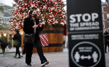 Una ciudadana con mascarilla junto al árbol de Navidad en Covent Garden en el centro de Londres. AFP