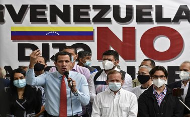 El líder opositor venezolano Juan Guaido hace gestos mientras habla durante una conferencia de prensa frente a un cartel que dice “Venezuela dijo no al fraude”, en el que anunció el lanzamiento de una consulta popular virtual para ignorar las últimas elecciones legislativas en Caracas. AFP