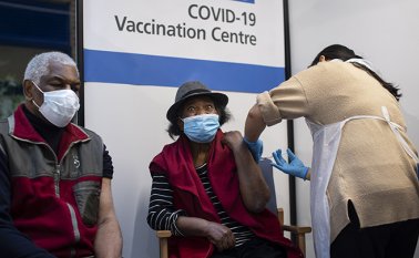 Una pareja de ancianos recibe la primera de dos vacunas Pfizer / BioNTech COVID.19. AFP