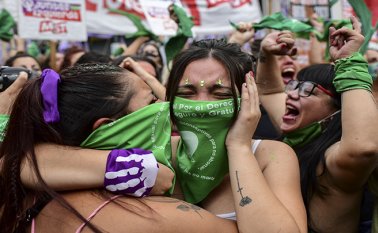 Los manifestantes celebran con pañuelos verdes, el símbolo de los activistas pro-aborto, frente al Congreso argentino en Buenos Aires. AFP