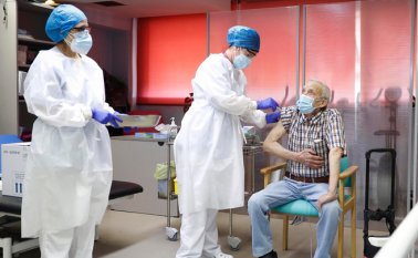 Una enfermera vacuna a Nicanor, de 72 años, con la dosis de Pfizer-BioNTech contra la COVID-19 en la residencia de ancianos de Vallecas, en Madrid, España.
 AFP