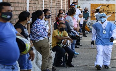Los venezolanos esperan en la fila para hacerse una prueba de COVID-19 en un centro de pruebas en Cúcuta. AFP