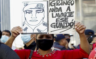 Un partidario del gobierno venezolano liderado por el presidente Nicolás Maduro sostiene una señal contra el líder opositor Juan Guaidó, frente a la Asamblea Nacional. AFP