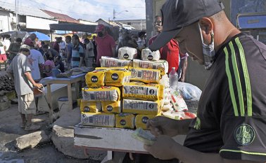 Las personas compran la comida en Trinidad y Tobago para enviarla a Venezuela en botes.  AFP