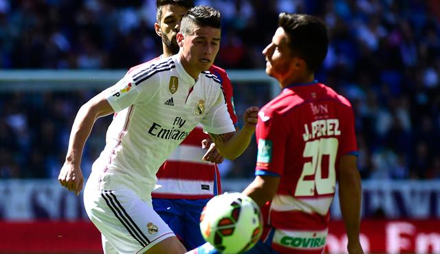 El centrocampista colombiano del Real Madrid James Rodríguez, junto al mediocampista de Granada Juan Carlos Pérez (derecha ) durante el partido de fútbol en el estadio Santiago Bernabéu. (Foto AFP)