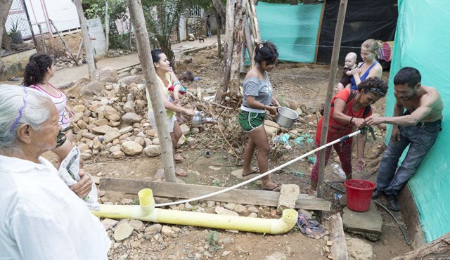 Los vecinos deben hacer fila para abastecerse de la única fuente de agua en esta invasión. En este mismo punto algunos se bañan. Juan Pablo Cohen