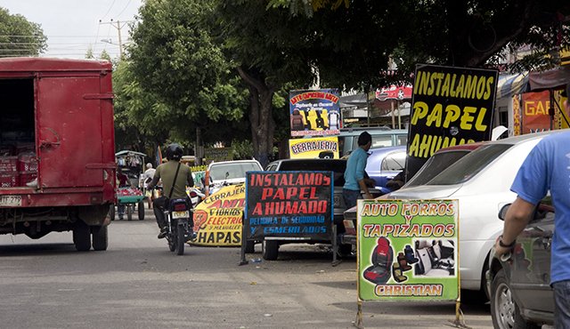 En todas las calles del barrio reina la contaminación visual, porque los propietarios de almacenes y talleres promocionan sus servicios en avisos que instalan en la calle. Archivo