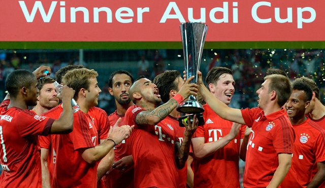 El centrocampista chileno Arturo Vidal y el defensa Philipp Lahm sostienen el trofeo de la Copa Audi. AFP
