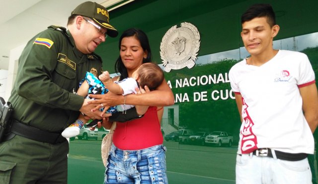 El comandante de la policía de cúcuta, coronel Jaime Barrera, le entregó el bebé rescatado a la madre. Policía Nacional