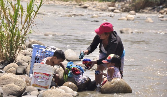 Estos niños le ayudan a su abuela a lavar la ropa al tiempo que le piden que se devuelvan para su casa en Venezuela. Edinsson Figueroa