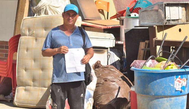 Antonio posa con el documento expedido por las autoridades venezolanas, y en el que se le reconoce como refugiado, frente a los pocos objetos que logró sacar de su vivienda y traer hasta La Parada. Edinsson Figueroa