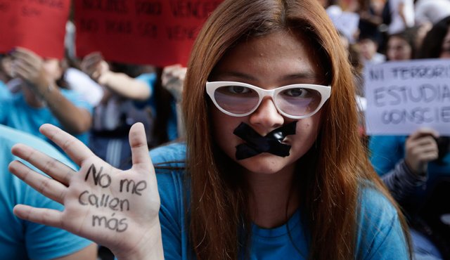 Una estudiante de secundaria con la boca cerrada muestra su mano cubierta con la frase: " No me callará", durante la protesta contra la corrupción frente al Ministerio de Educación. AP