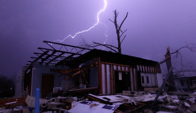 Momento en el que un relámpago ilumina una casa después de que un tornado tocó tierra en el condado de Jefferson, Estados Unidos, dañando varias casas, este viernes. AP