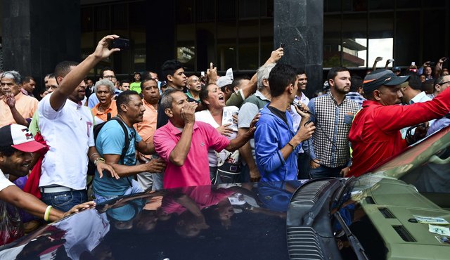 Seguidores del presidente venezolano, Nicolás Maduro, lanzan insultos al diputado Henry Ramos Allup, el presidente electo del nuevo parlamento a su llegada ayer a Caracas. AFP