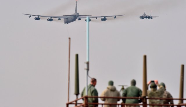 Soldados estadounidenses ven un avión estadounidense B-52 Stratofortress, escoltado por un F-15K caza que vuela sobre la Base Osan en Pyeongtaek, al sur de Seúl. AFP