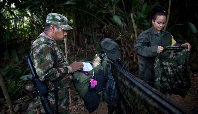 Juan Pablo, comandante del Frente 36 de las Farc, trabaja en su computadora portátil al lado de su novia, de 25 años, la combatiente rebelde Tania, en una campamento oculto en Antioquia. AP