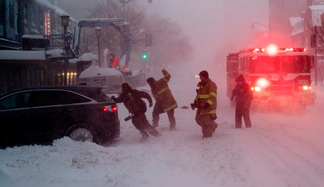 Bomberos ayudan a empujar un coche atascado después la tormenta de nieve. La tormenta afectó a Nueva York, Filadelfia, Washington y Baltimore. AFP