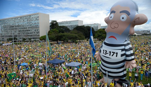 Un gigantesco muñeco inflable que asemeja a la figura del expresidente Luiz Inacio Lula da Silva vestido de presidiario se erigía entre las cabezas apiñadas frente al Congreso. AFP
