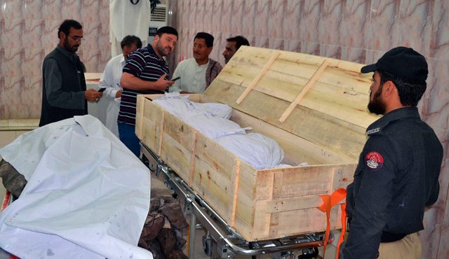 Funcionarios de seguridad paquistaníes y el personal del hospital junto a los cadáveres en un hospital en Quetta, a donde fueron llevados después de un ataque aéreo que tenía como objetivo al jefe de los talibanes afganos Ajtar Mansur. AFP