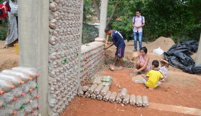 A diario la familia santafé arias llena las botellas plásticas de arena y termina de levantar los muros plásticos para terminar rápidamente su vivienda ecológica. Rodrigo Sandoval