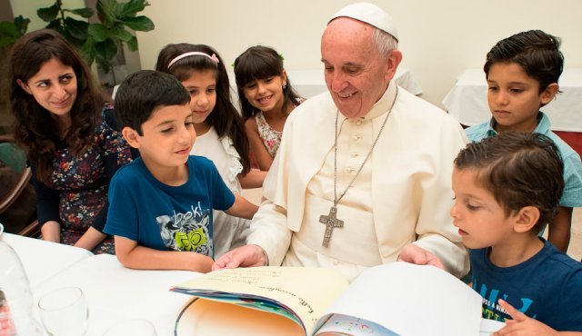 Aquí aparece el papa Francisco observando algunos dibujos, acompañado de niños de familias refugiadas. AP