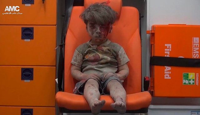 El niño fue captado aturdido y cansado, sentado en la silla naranja de una ambulancia. La imagen fue tomada de un video distribuido por el grupo opositor sirio Aleppo Media Center (AMC). AP