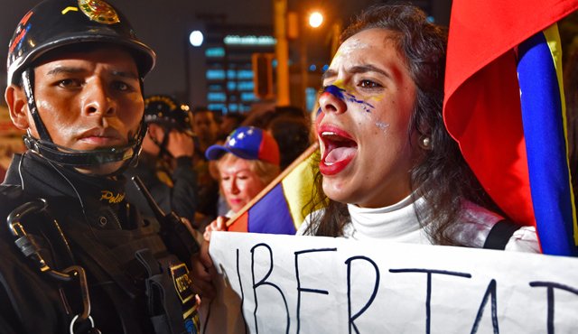 Maduro se trasladaba a pie por el sector Villa Rosa y los residentes de la zona salieron a protestar contra el mandatario, rodeándole mientras hacían sonar cacerolas. AFP