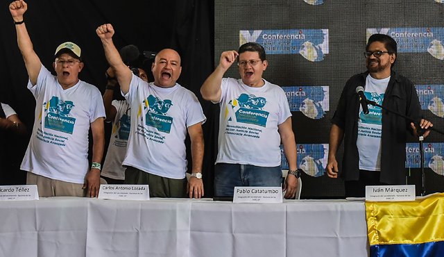 los miembros de las Fuerzas Armadas Revolucionarias de Colombia (Farc) Ricardo Téllez, Carlos Antonio Lozada, Pablo Catatumbo e Iván Márquez celebran la aprobación del acuerdo de paz con el gobierno durante la ceremonia de clausura de la Décima Conferencia Nacional Guerrillera en los Llanos del Yarí. AFP