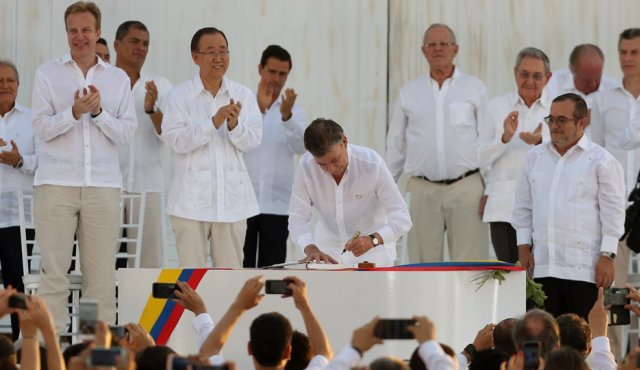 Momento en el que el presidente Santos estampa su firma en el Acuerdo Final de Paz. AFP