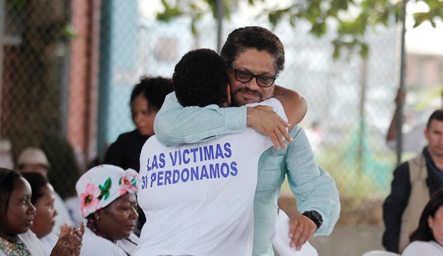 Iván Márquez abraza a una familiar de las víctimas de la masacre. Colprensa