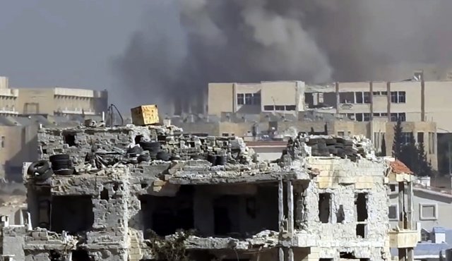 Esta escena tomada de un video proporcionado por la red de noticias Baladi, un medio opositor sirio, muestra el humo alzándose de un ataque sobre una academia militar del gobierno sirio en el oeste de Aleppo, Siria. AP