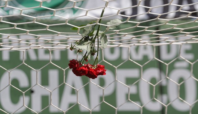 Flores cuelgan de la red de una portería en el estadio Arena Conda, en Chapecó, por la tragedia que embarga a la ciudad sede el equipo. AP