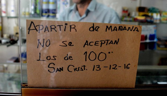 Con carteles en los que se leía "Sólo se recibe billetes de 100 bolívares hasta mañana", algunos comercios recibieron a decenas de clientes presurosos que salieron este lunes a realizar sus compras habituales. AFP