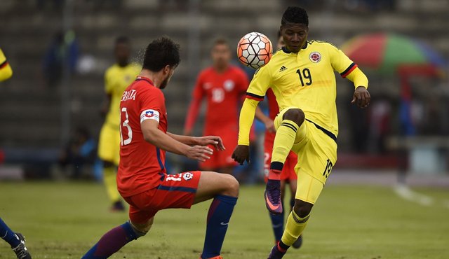 El jugador colombiano Jorge Obregón (der.) compite por el balón con el jugador chileno Francisco Sierralta durante su partido de fútbol Sub-20 en el estadio Olimpico de Riobamba. AFP