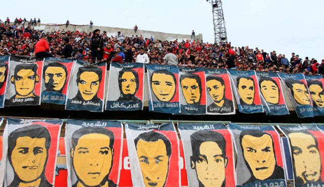 Los rostros las 74 víctimas permanecen colgados en una de las tribunas del estadio.