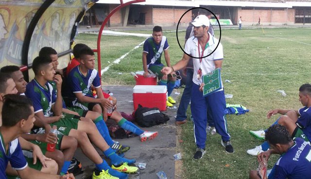 Freddy Alexander Figueroa, de pie y con un tablero en la mano, da las indicaciones del partido a su equipo de fútbol de Puerto Santander. Cortesía