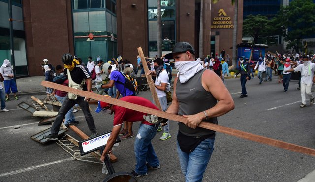 Algunos de los manifestantes portan cualquier clase de armas para atacar a las fuerzas militares que protegen y apoyan al gobierno de Nicolás Maduro. AFP
