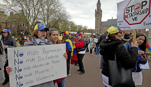 Con gorras y chaquetas con los colores de la bandera del país sudamericano, algunas personas mostraban pancartas en las que pedían detener la que califican como “dictadura” en Venezuela. AP