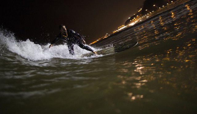 En esta foto del 26 de abril de 2017, Ernesto Benavides monta una ola en las aguas de la playa de La Pampilla en Lima, Perú. Cuando los casi 10 millones de habitantes de Lima se alistan para dormir, un puñado de surfistas baja hasta la única playa de Perú donde se puede correr olas por la noche AP