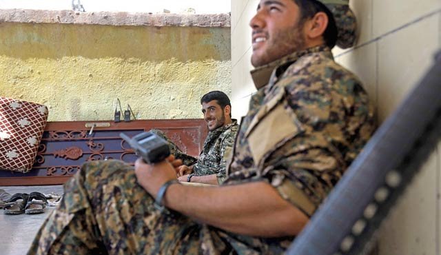 Miembros de las Unidades de Protección del Pueblo Kurdo (GPJ) descansan tras tomarse el barrio al-Dariya de la ciudad siria de Raqa, durante una ofensiva de los combatientes respaldados por EE. UU. para retomar la ciudad en poder del EI. AFP