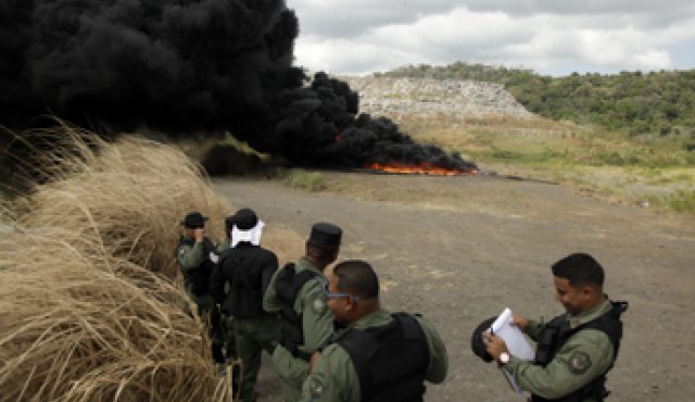 Agentes de la Policía observan la incineración del alijo de drogas incautado en Ciudad de Panamá. En el recuadro, paquetes de cocaína y píldoras de efedrina y metanfetamina que hacían parte del cargamento incautado.