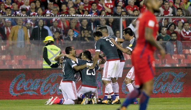 Paraguayos celebran una de sus anotaciones, mientras Arturo Vidal se aleja decepcionado. AFP
