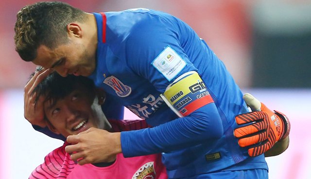 Giovanni Moreno (der.) abraza a Yan Yanling de Shangai SIPG durante su partido de fútbol FA Cup en Shanghai. AFP