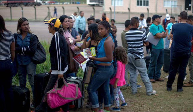 Esta imagen tomada el 28 de febrero muestra a venezolanos en una fila frente a la Oficina de la Policía Federal de Brasil, en Roraima. Al menos 50 mil venezolanos han llegado por vía terrestre al ese estado. AFP