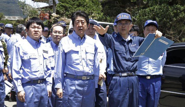 El primer ministro de Japón, Shinzo Abe (centro), inspeccionó una zona inundada en Seiyo, prefectura de Ehime, este viernes. AFP
