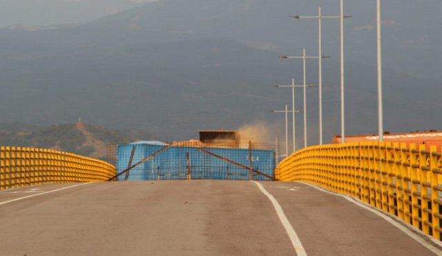 En la imágen se puede observar como es llenado uno de los contenedores, ejercicio que aumenta la carga del puente, poniendo en riesgo la estructura y llevándolo incluso a que pueda colapsar. Migración Colombia