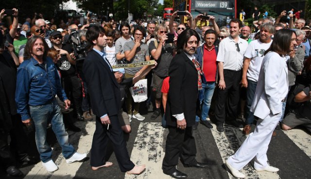 La foto muestra a los cuatro miembros del grupo atravesar un paso peatonal frente a los estudios Abbey Road. AFP