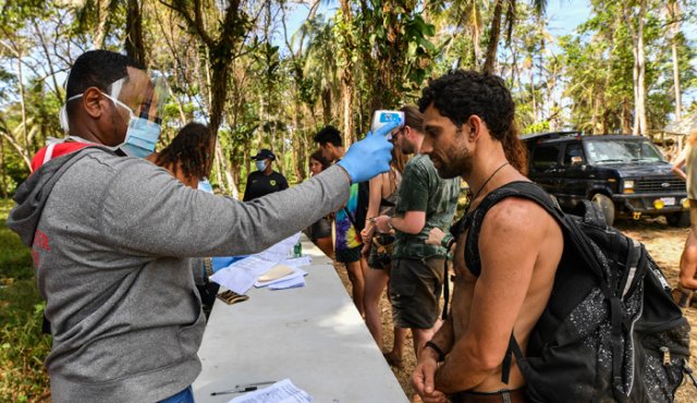 Un trabajador de salud de Panamá verifica la temperatura de un asistente del festival de rock Tribal Gathering en Cuango, provincia de Colón.
AFP