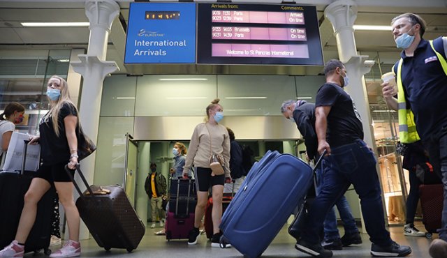 Los pasajeros que usan máscaras faciales como precaución contra la propagación del nuevo coronavirus caminan a través de las llegadas hasta el vestíbulo principal de la estación internacional de St Pancras en Londres. AFP